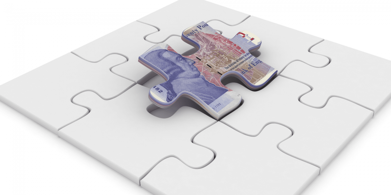 Plain jigsaw with money on one of the pieces